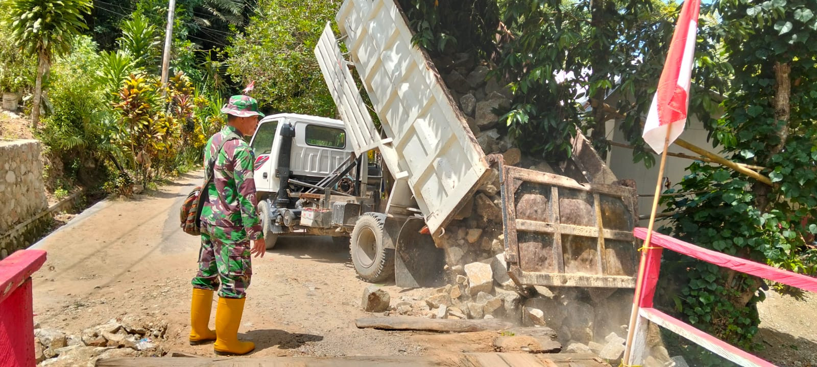 Babinsa Kawal Pengangkutan Material Batu Gunung Demi Kelancaran Pembangunan Jembatan Perintis Garuda di Desa Ulapato B